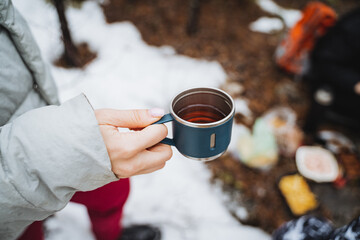 Tea in kurzhka holding man on the background of the forest, drinking delicious hot drink in nature,...