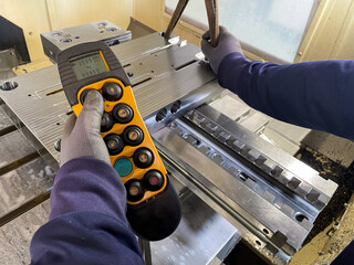 working hands, yellow remote control for overhead crane, with 5 ton hook holding steel mold