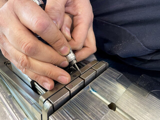 working hands, finishing with a precision tool on a steel mould