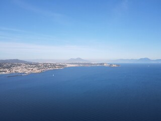 Obraz premium Explore the stunning coastline of a Southern Italian city Baia through breathtaking drone footage: crystal-clear waters, rugged cliffs, and colorful houses blend into an enchanting landscape