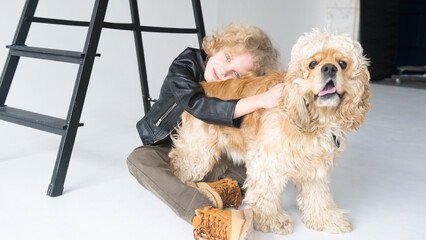 Young Boy in Casual Attire Embracing a Fluffy Dog in a Bright Studio Setting