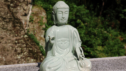 Fototapeta na wymiar A large stone statue of a seated Buddha. Garden Sculptures. South Korea