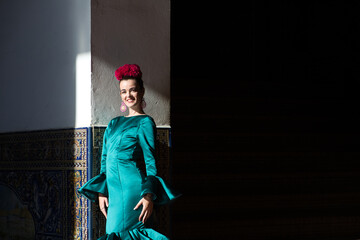 Young and beautiful woman with typical green frilly dress and dancing flamenco in plaza de espana...