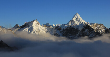 Mount Ama Dablam and other mountains reaching out of a sea of fog, Nepal.