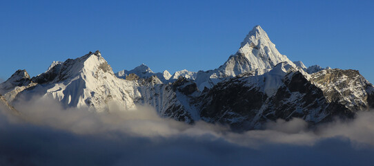 Mount Ama Dablam and other snow covered mountains reaching out of a sea of fog, Nepal.