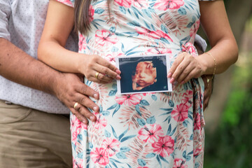 Big Pregnant belly with echography showing baby picture motherhood