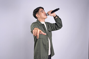 Stylist asian men singing songs with microphone, holding mic and dancing at karaoke isolated white background.