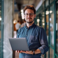A male person chief analyst office holding a laptop