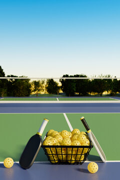 Pickleball rackets and balls in a basket on a sports field. Trees in the background. 3d rendering.
