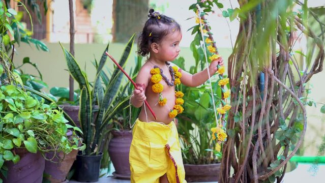 Cute Indian boy dresses as lord rama in action with bow at outdoor with from different angle at day