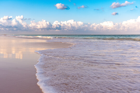 Waves washing over pink sand at Pink Sands Beach on Harbour Island, Bahamas, under a blue summer sky