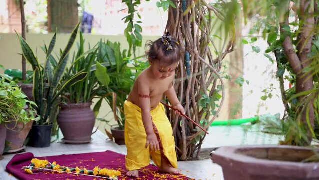 Cute Indian boy dresses as lord rama in action with bow at outdoor with from different angle at day