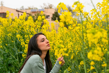 Mujer admirando los campos de colza en flor - obrazy, fototapety, plakaty