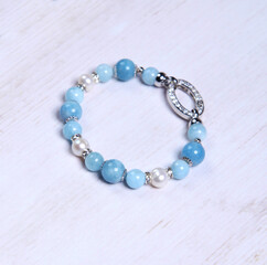 Aquamarine bracelet. Bracelet made of stones on hand from natural stone Aquamarine. Bracelet made of natural stones with an elastic band. Handmade jewelry bracelets on light modern background.