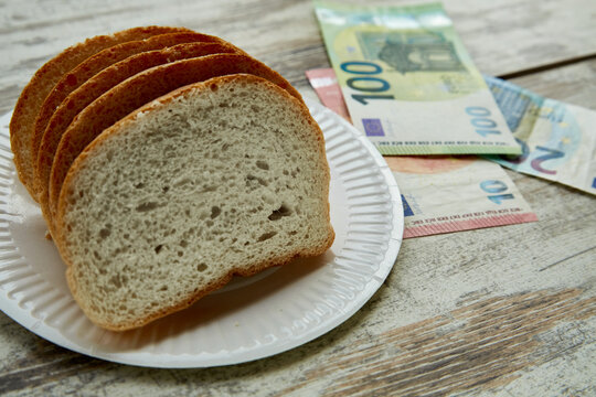Bread on a plate on the table next to euro bills of different denominations, sale of bread in Europe