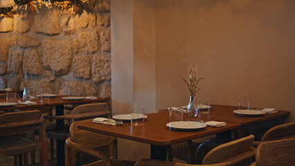 Cozy served restaurant tables under warm light original lamps. Cafe interior