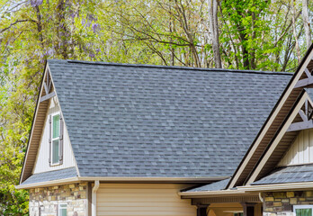 Asphalt shingles are used as roofing materials on roof of newly constructed house © ungvar