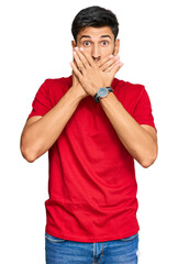 Young handsome man wearing casual red tshirt shocked covering mouth with hands for mistake. secret concept.