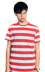 Handsome hipster young man wearing casual striped t shirt skeptic and nervous, frowning upset because of problem. negative person.