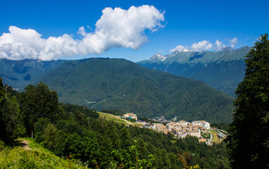 Fototapeta premium Beautiful panoramic landscape - view of Glade 960 with modern luxury hotels among the green mountains on a sunny summer day in Russia