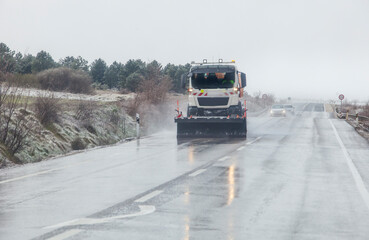 Snow plow patrolling the road in a sleet