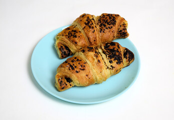 Handmade croissant with chocolate on blue plate on white background 
