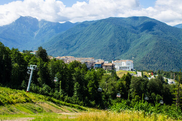 Beautiful panoramic landscape - view of Glade 960 with modern luxury hotels among the green mountains on a sunny summer day in Russia