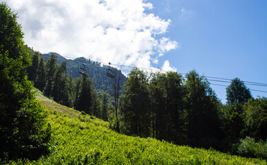 Beautiful panoramic mountain landscape with green trees and mountain slopes on a sunny summer day...