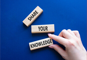 Share your knowledge symbol. Concept word Share your knowledge on wooden blocks. Businessman hand. Beautiful deep blue background. Business and Share your knowledge concept. Copy space