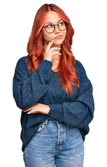 Young redhead woman wearing casual sweater and glasses serious face thinking about question with...