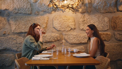 Lgbt couple dating cafe enjoying cozy atmosphere. Smiling two women talking 