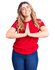 Young caucasian woman wearing casual clothes praying with hands together asking for forgiveness...