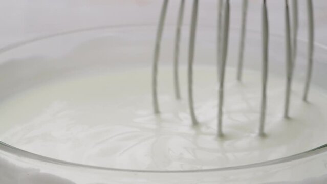 White creamy sauce texture close-up. Dipping and whisking by corolla a white yogurt macro. Dairy products concept. 