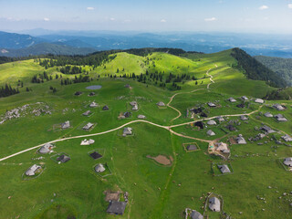 Aerial View of Mountain Cottages on Green Hill of Velika Planina Big Pasture Plateau, Alpine Meadow Landscape, Slovenia - 780822813