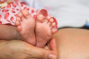 mother finger holding a child foot