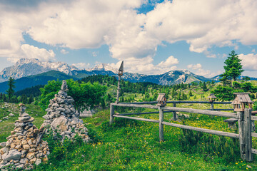 Old Wooden Fence and Pile of Stones. Mountains in the Background in Velika Planina, Slovenia - 780823605