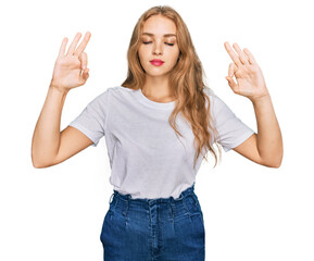 Young caucasian girl wearing casual white t shirt relax and smiling with eyes closed doing meditation gesture with fingers. yoga concept.