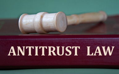 ANTITRUST LAW - words on a burgundy folder on the background of a judge's gavel