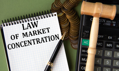 LAW OF MARKET CONCENTRATION - words in a notepad against the background of a calculator and a judge's gavel