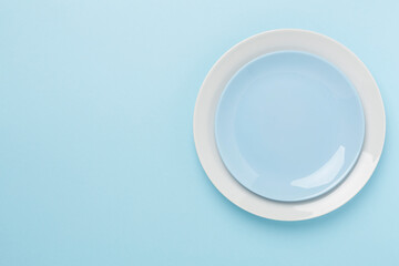 Empty plate with tablecloth on color background, top view