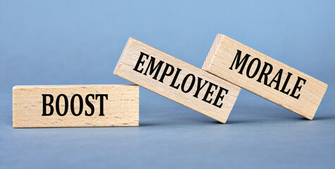 BOOST EMPLOYEE MORALE - words on wooden blocks on blue background