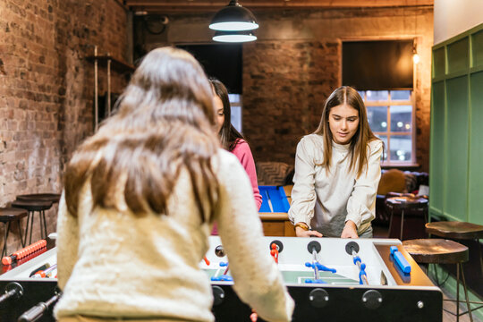 Young women friends enjoying a game of foosball
