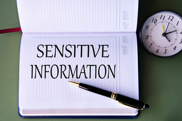 SENSITIVE INFORMATION - words in a white notebook on a dark green background with a clock