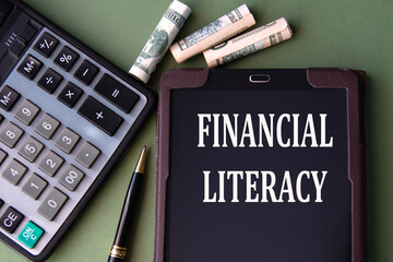 FINANCIAL LITERACY - words in an electronic notebook on the background of a calculator and banknotes