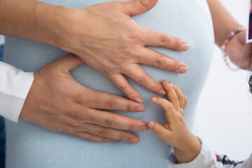 Family members hands touching holding their mother big pregnant belly family 