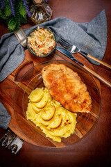 Breaded chicken breast fillet served with boiled potatoes and salad. - 780836829