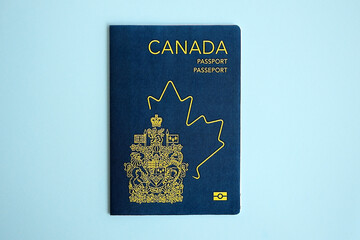 Fototapeta premium Canadian passport on blue background close up. Tourism and citizenship concept