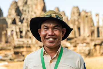 Friendly guide smiling in front of Angkor Wat temple