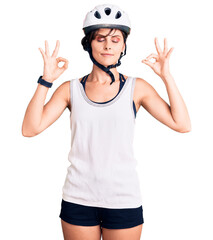 Beautiful young woman with short hair wearing bike helmet relax and smiling with eyes closed doing meditation gesture with fingers. yoga concept.