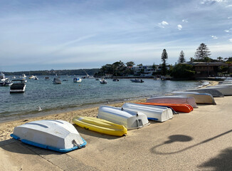 Boats on the beach. Canoes along the shore of the ocean. Sailing boats at the distance. Tourist...
